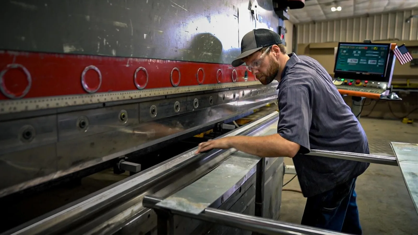 A machine operator bending steel at a press brake
